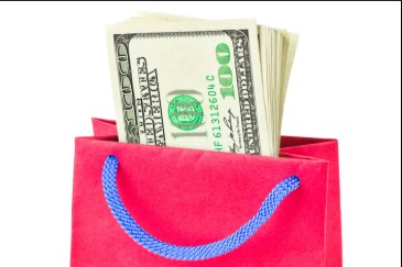 money dollars in a pink shopping bag
